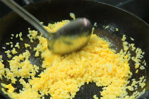 大火加熱炒鍋，再入油，燒到四至五成熱時(shí)倒入雞蛋液，在未凝結(jié)之前，加米飯煸炒，不停翻炒并用鍋鏟將成塊的米飯碾開(kāi)、撥散。