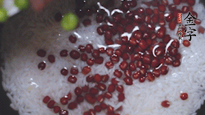 將炒好的食材和大米、紅豆一起放進(jìn)電飯鍋煮。