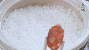 煮開(kāi)后轉(zhuǎn)小火，當(dāng)米飯出現(xiàn)小孔時(shí)，鋪上金字麻辣香腸。