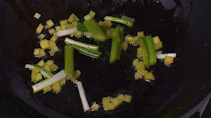 鍋中熱油，依次下姜粒、蔥段、蘆筍炒香。
