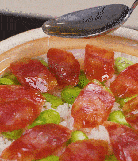 大米出現(xiàn)小孔時(shí)開蓋放香腸，往鍋邊淋入少許油，再燜煮8~10分鐘左右。