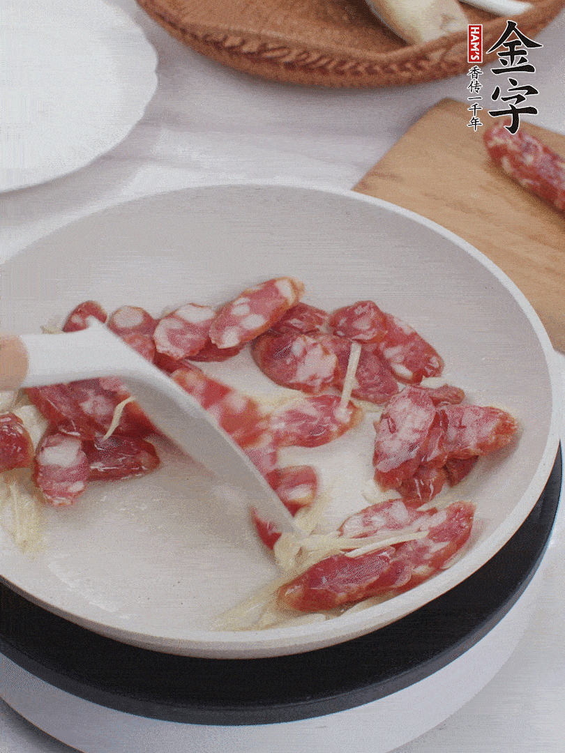 油溫3成熱時(shí)，下姜絲、蒜片、香腸炒出油脂。