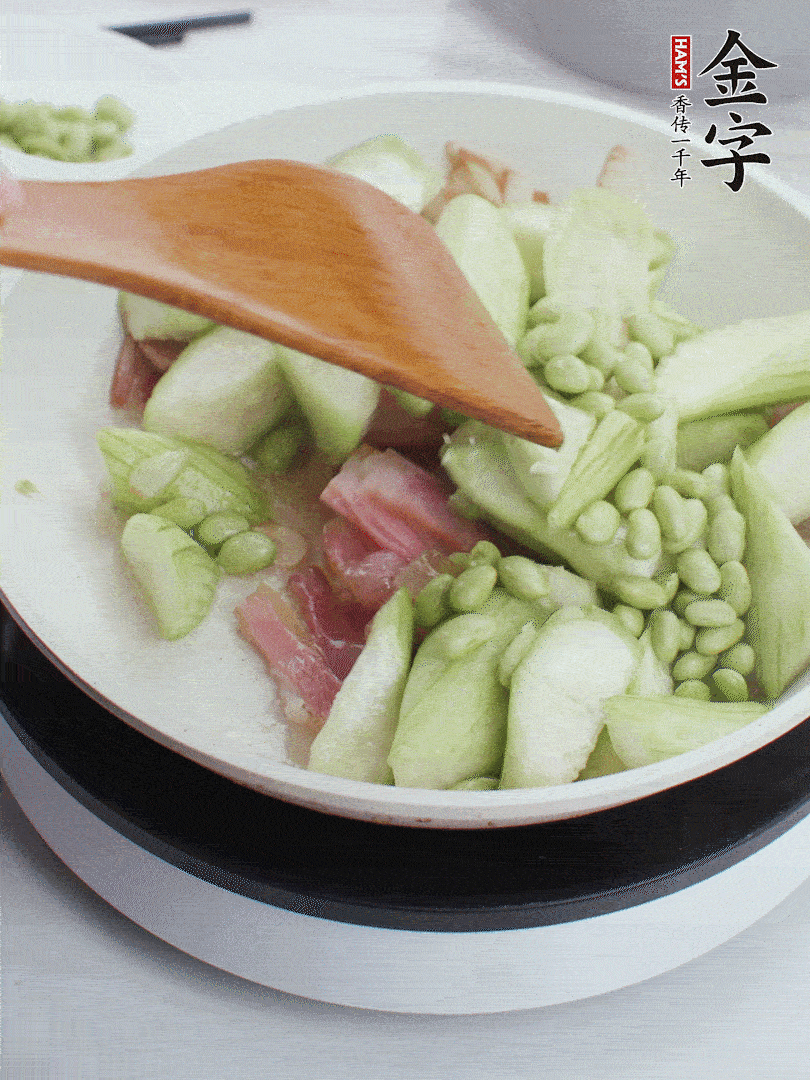 依次下絲瓜、青豆翻炒，炒至絲瓜打蔫縮小。