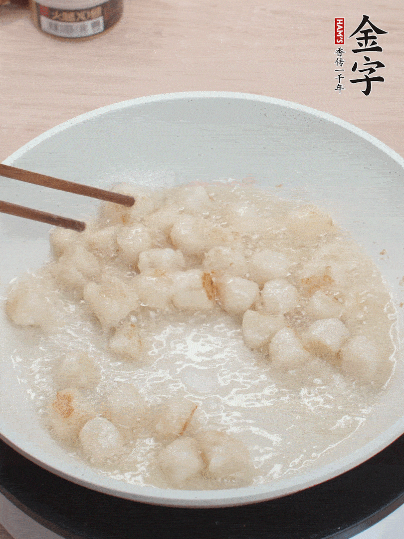 油溫4成熱，鮮貝蘸干淀粉下鍋煎，一面微黃后翻面。