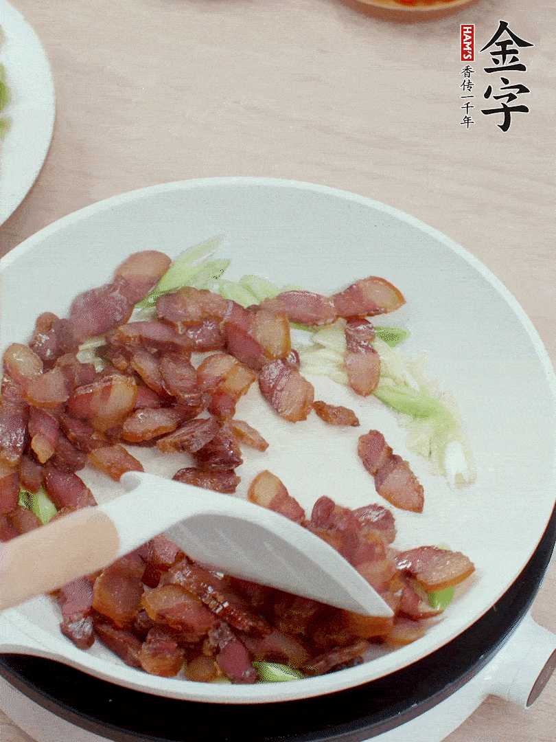 鍋中少許油，姜、蒜白爆香，下臘肉煸出油脂。