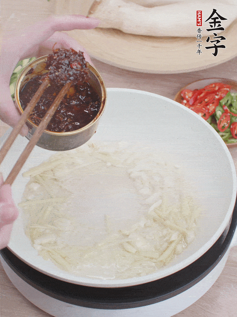 起鍋熱油，姜蒜、金字火腿干貝醬煸香。