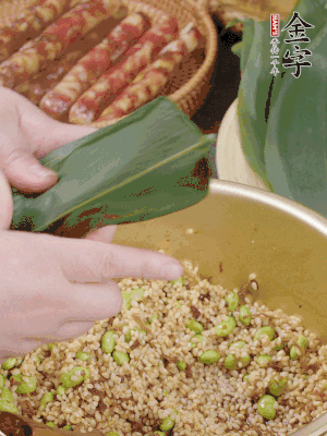 粽葉往下折，完全蓋住，兩側捏緊。