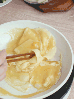 油6成熱時，下雞蛋液，邊緣凝固時翻拌成塊狀。