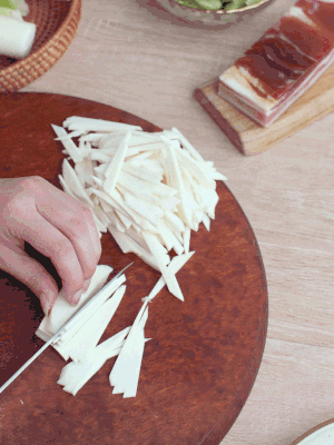 茭白切細(xì)絲，鹽水中浸泡防止氧化。