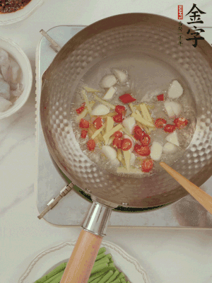 油7成熱時(shí)，下大蒜粒、姜絲、小米辣煸香。