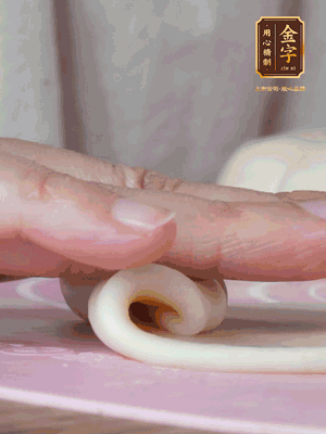 做面劑 油皮按扁，中間包入一個油酥，邊緣收緊捏死。包好的面劑按扁，用搟面杖搟壓成橢圓形。從底部向上卷成筒狀，用保鮮膜蓋好松弛15分鐘，再把筒狀縱向搟壓成長條狀。再卷一次，松弛20分鐘