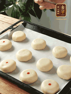 收口向下放在案板上，輕輕將月餅坯按扁，用筷子點紅點做裝飾